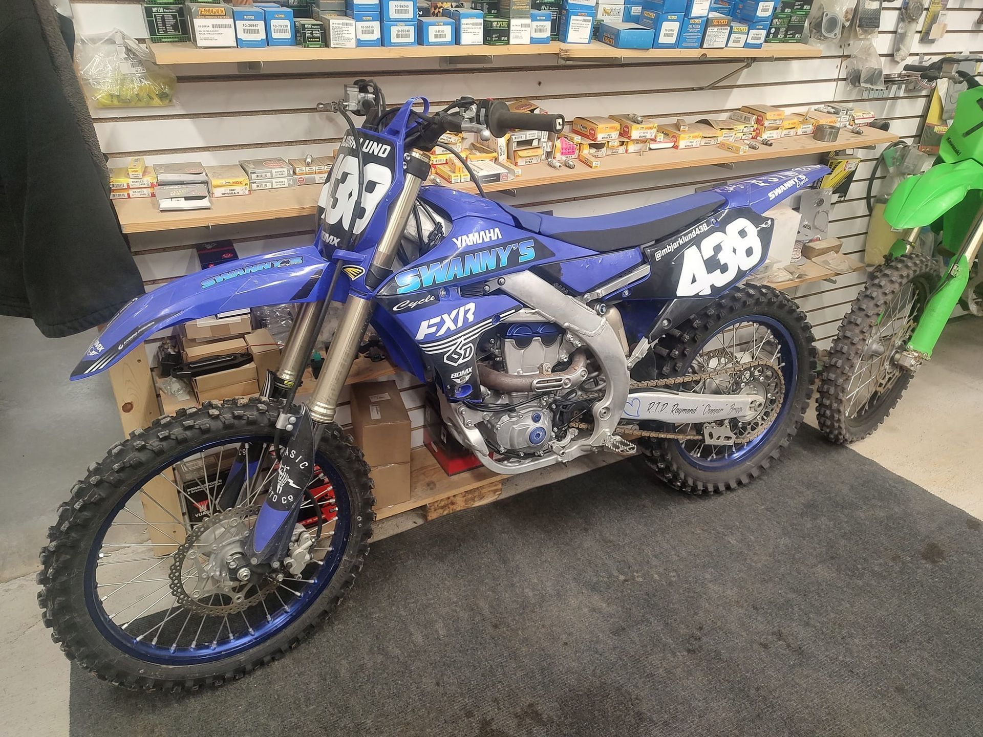 Blue Yamaha dirt bike with number 437 on display in a store.