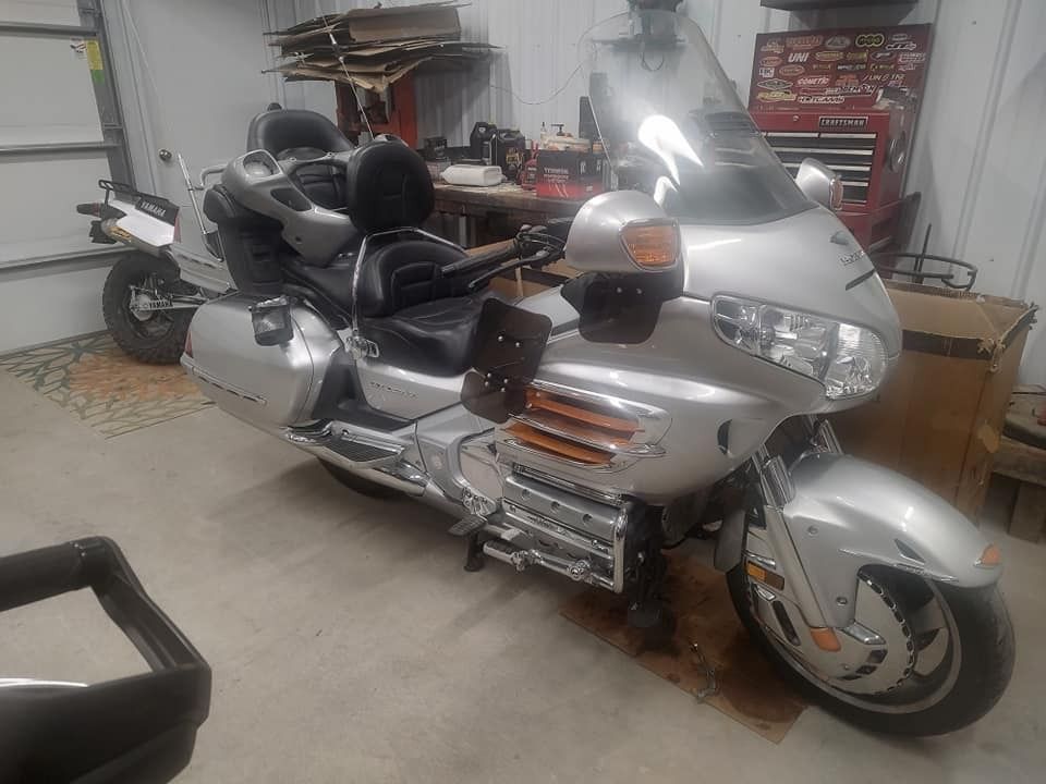 Silver Honda Goldwing motorcycle parked indoors.