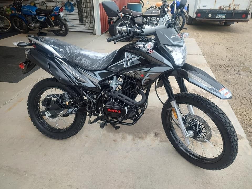 Black dual-sport motorcycle parked on a concrete surface.