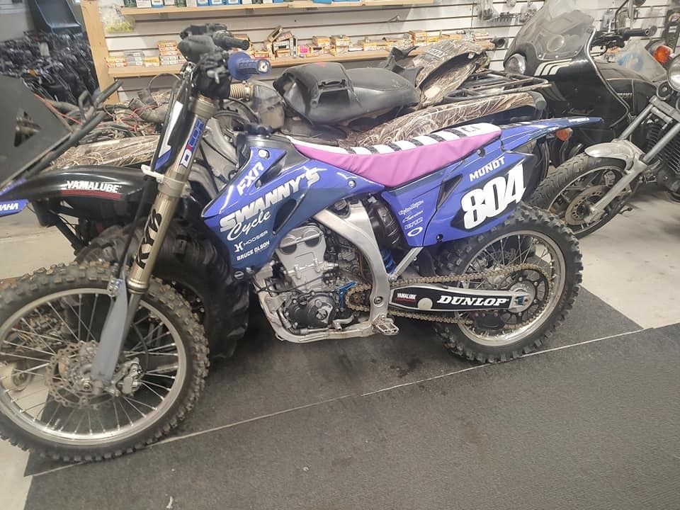 Blue and white Yamaha dirt bike with pink seat, number 804.