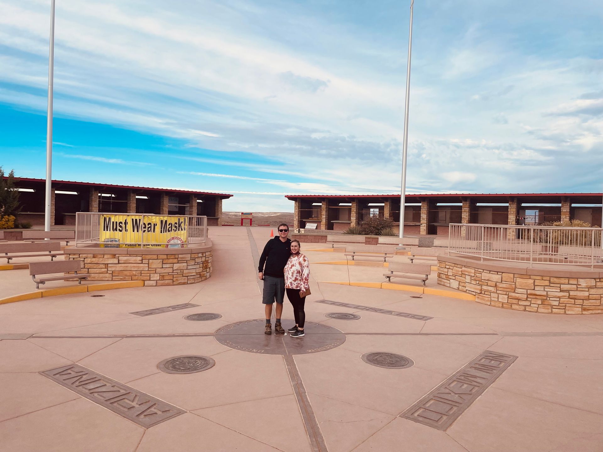 A man and a woman are posing for a picture in front of a building.