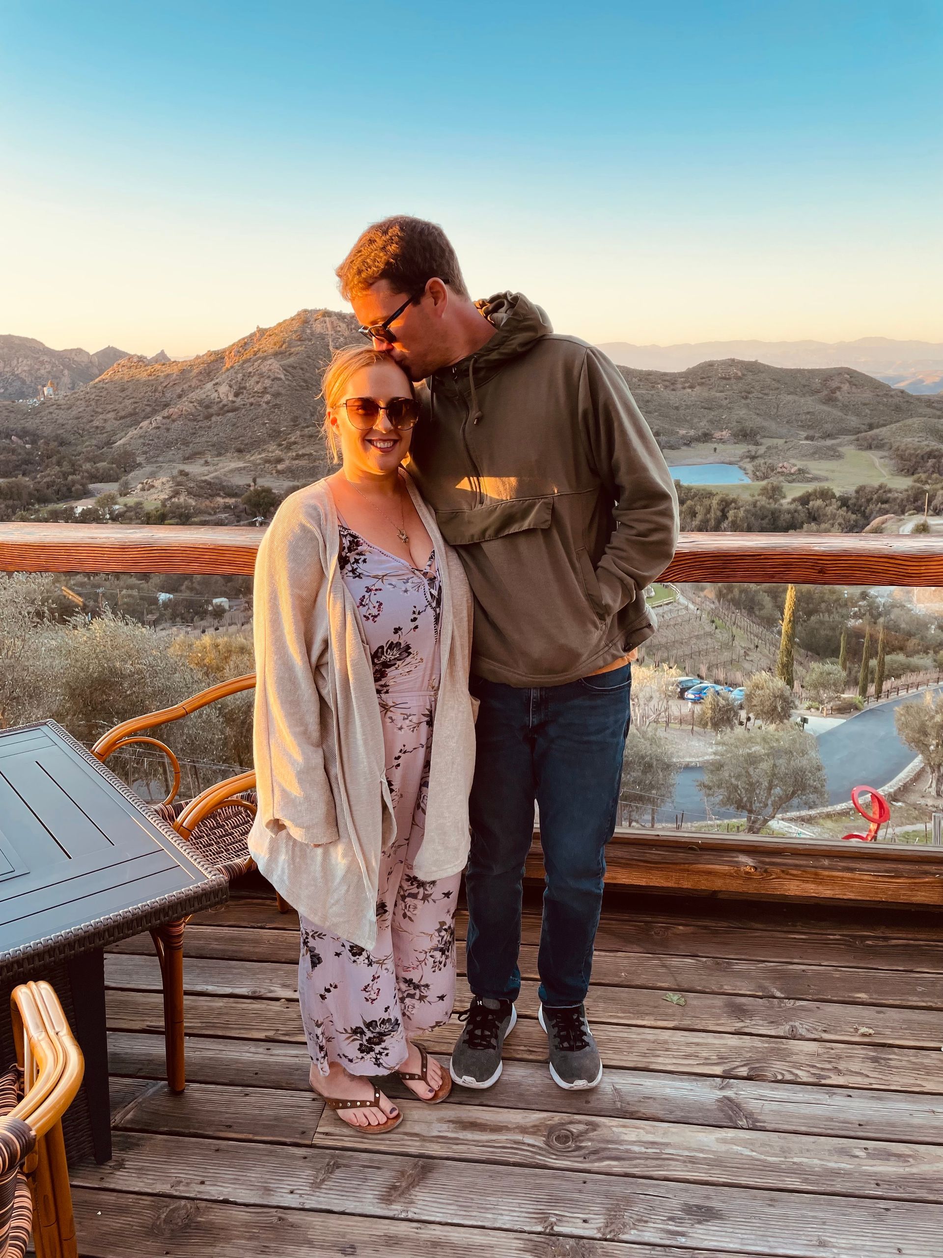A man and a woman are standing next to each other on a wooden deck.