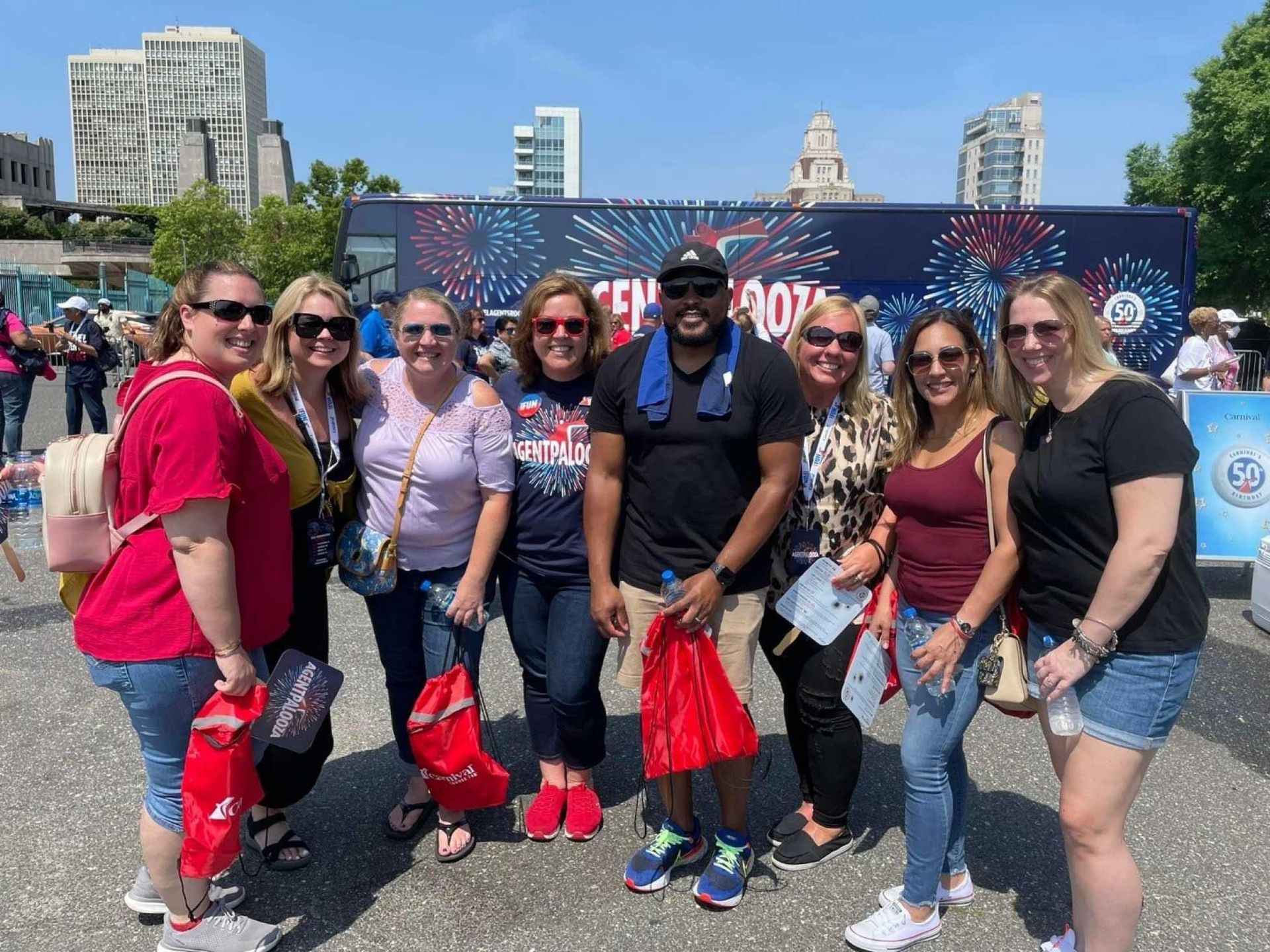 a group of people smiling for a photo outdoors in front of a bus