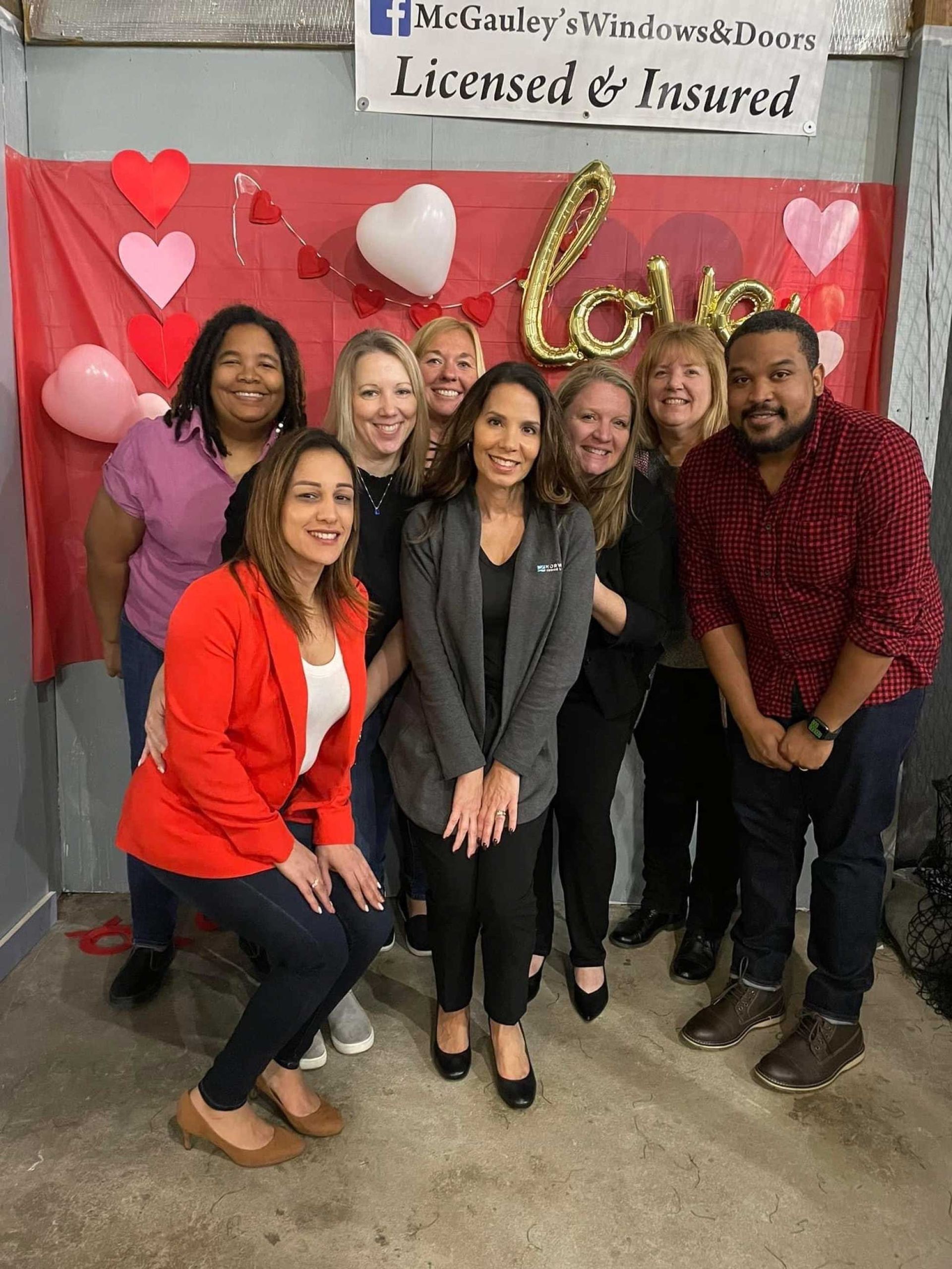 a group of people posing for a photo with Valentine's Day decorations