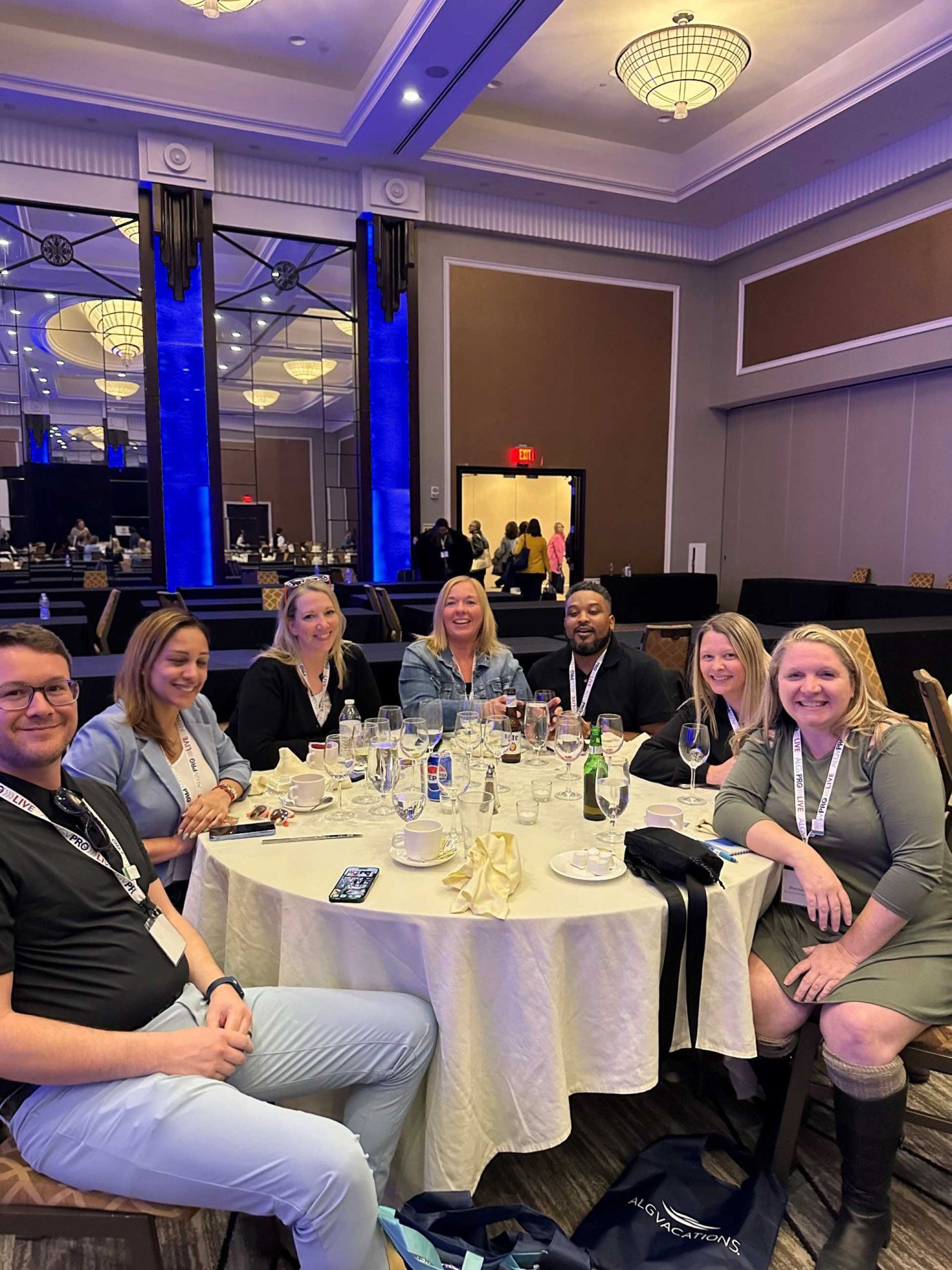 a group of people seated around a round table in a hotel ballroom