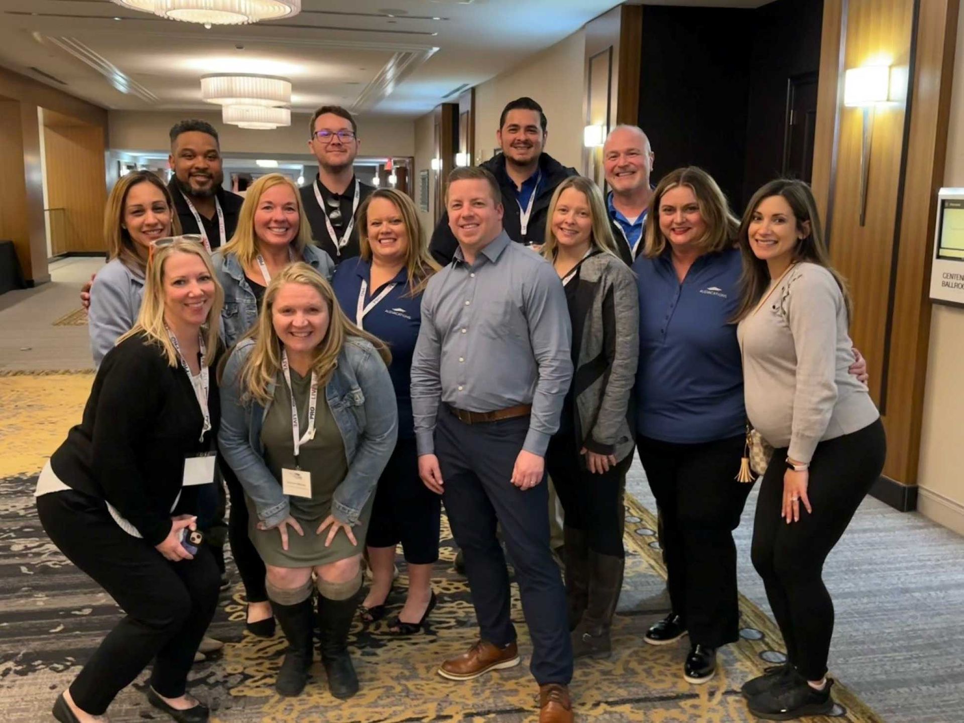 a group of people posing for a photo in a hotel hallway
