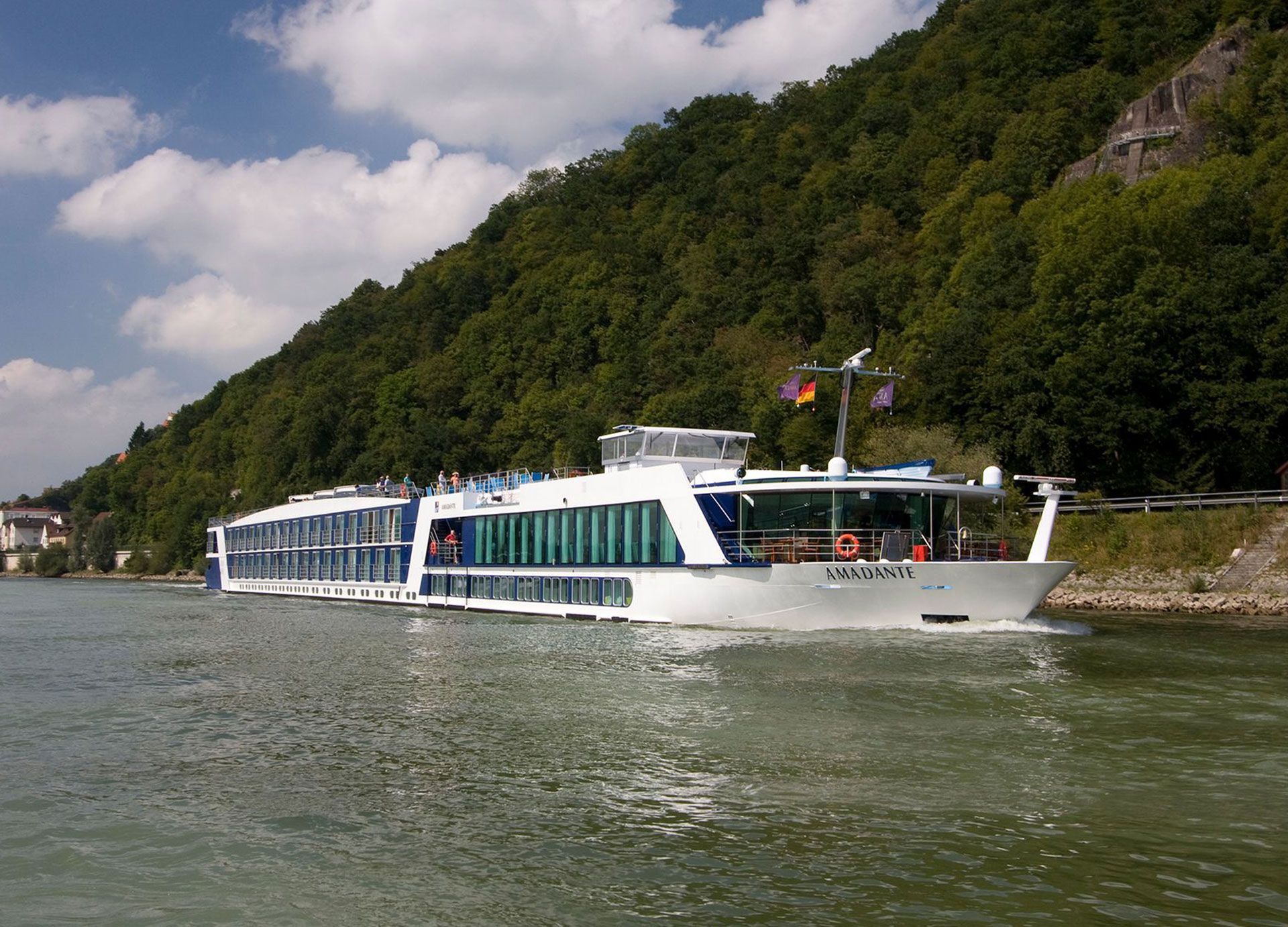 A large cruise ship is floating on a river