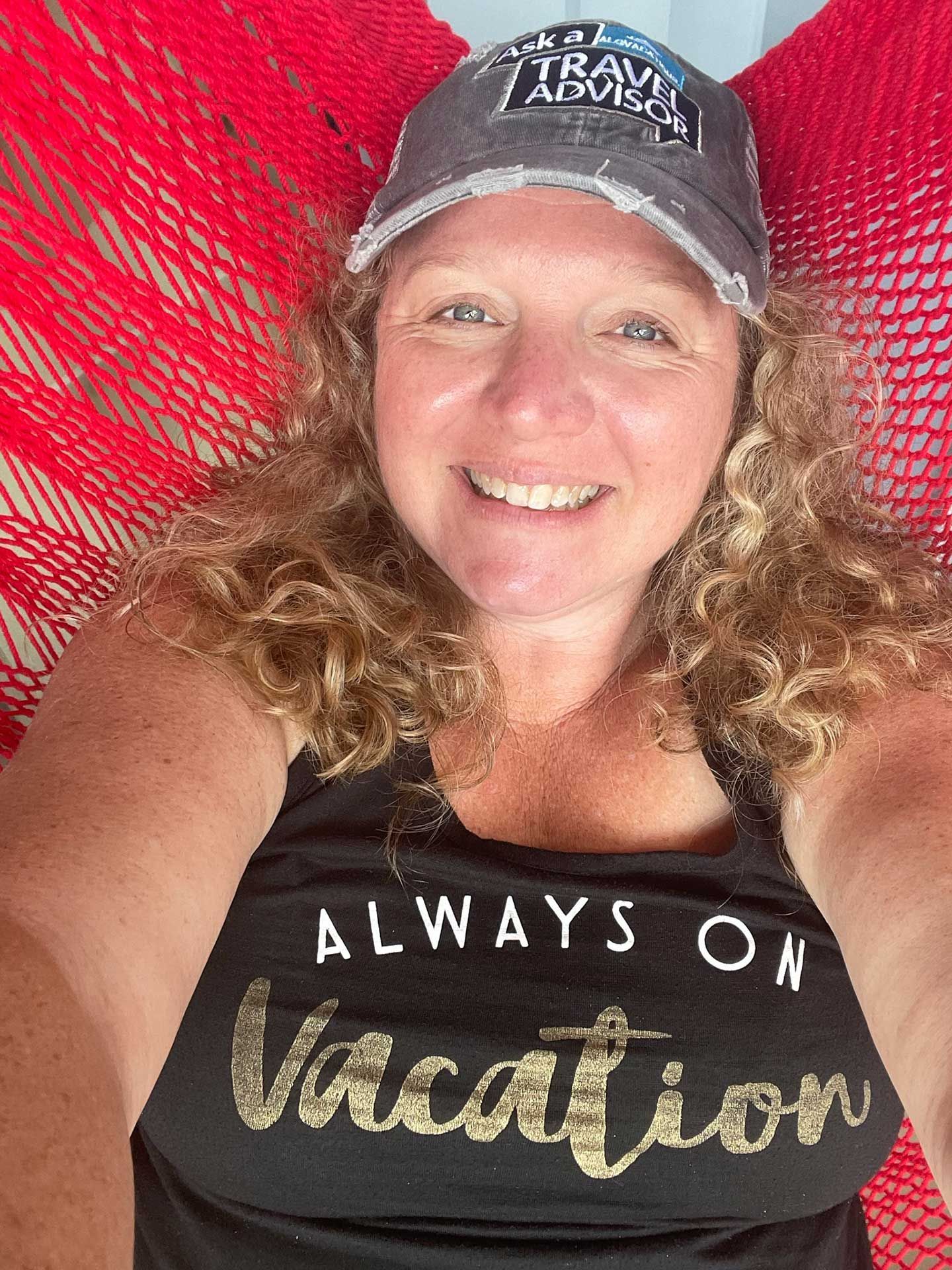 a woman in a hammock, wearing a hat and tank top