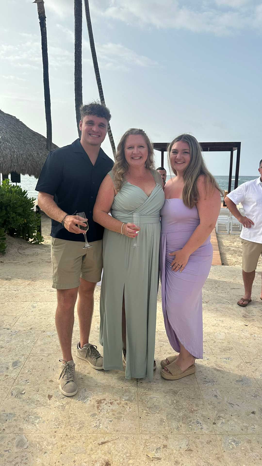 three people smiling on a beach