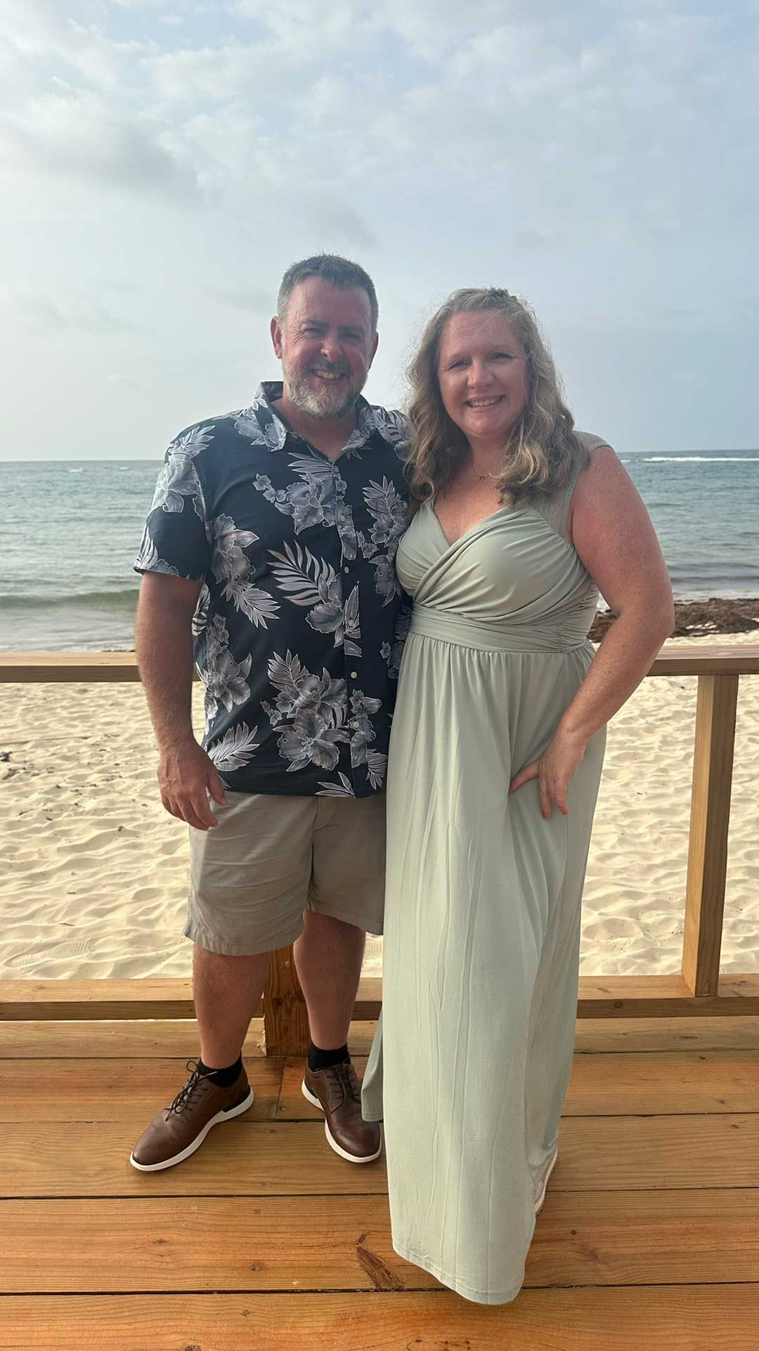 a couple posing outdoors by the ocean