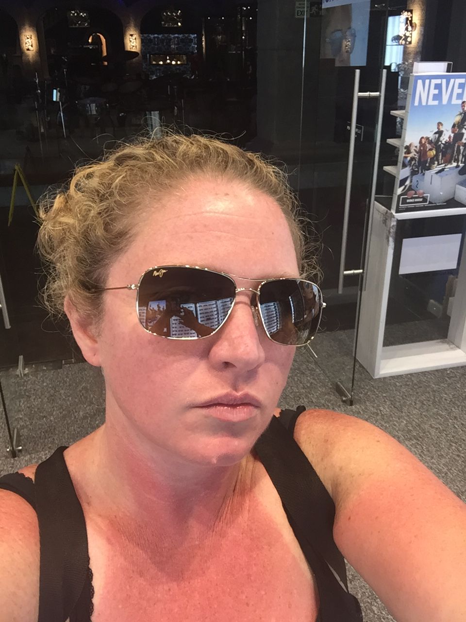 a woman with curly blonde hair wearing sunglasses