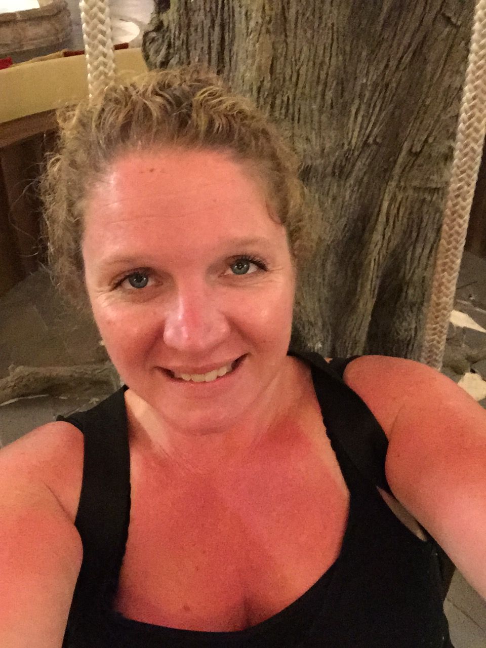 a woman smiles at the camera, her skin slightly sunburned