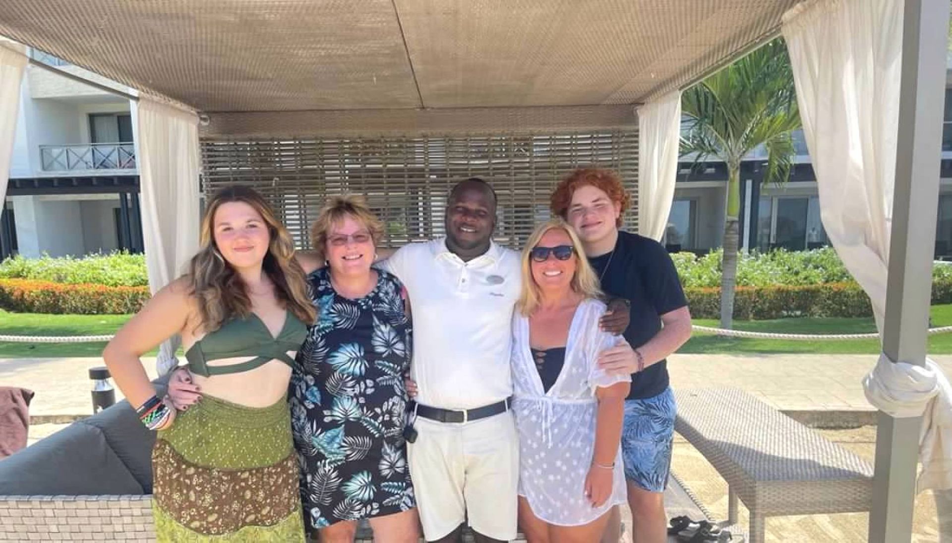 A group of people are posing for a picture under a gazebo
