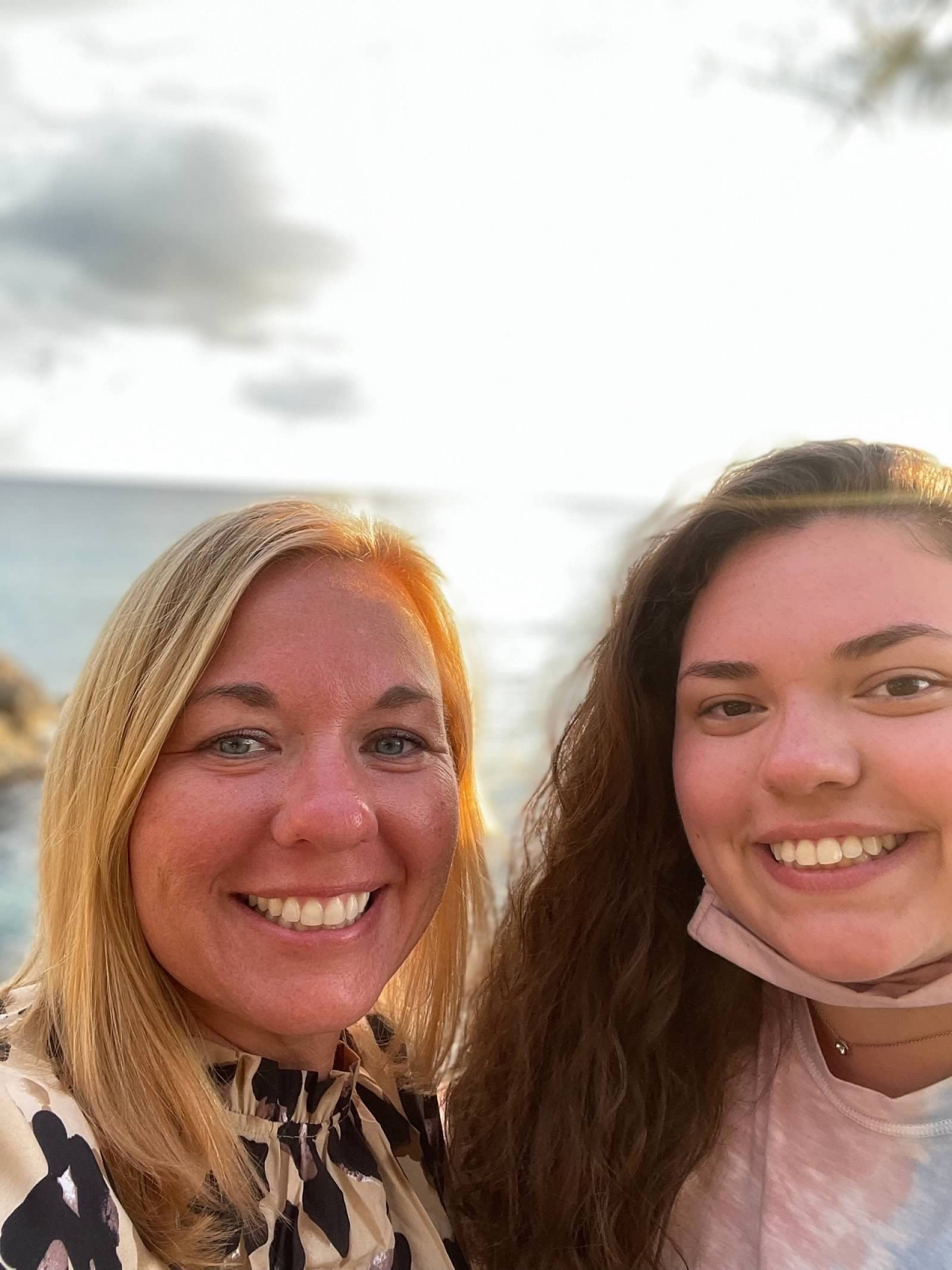 Two women are posing for a picture together and smiling for the camera