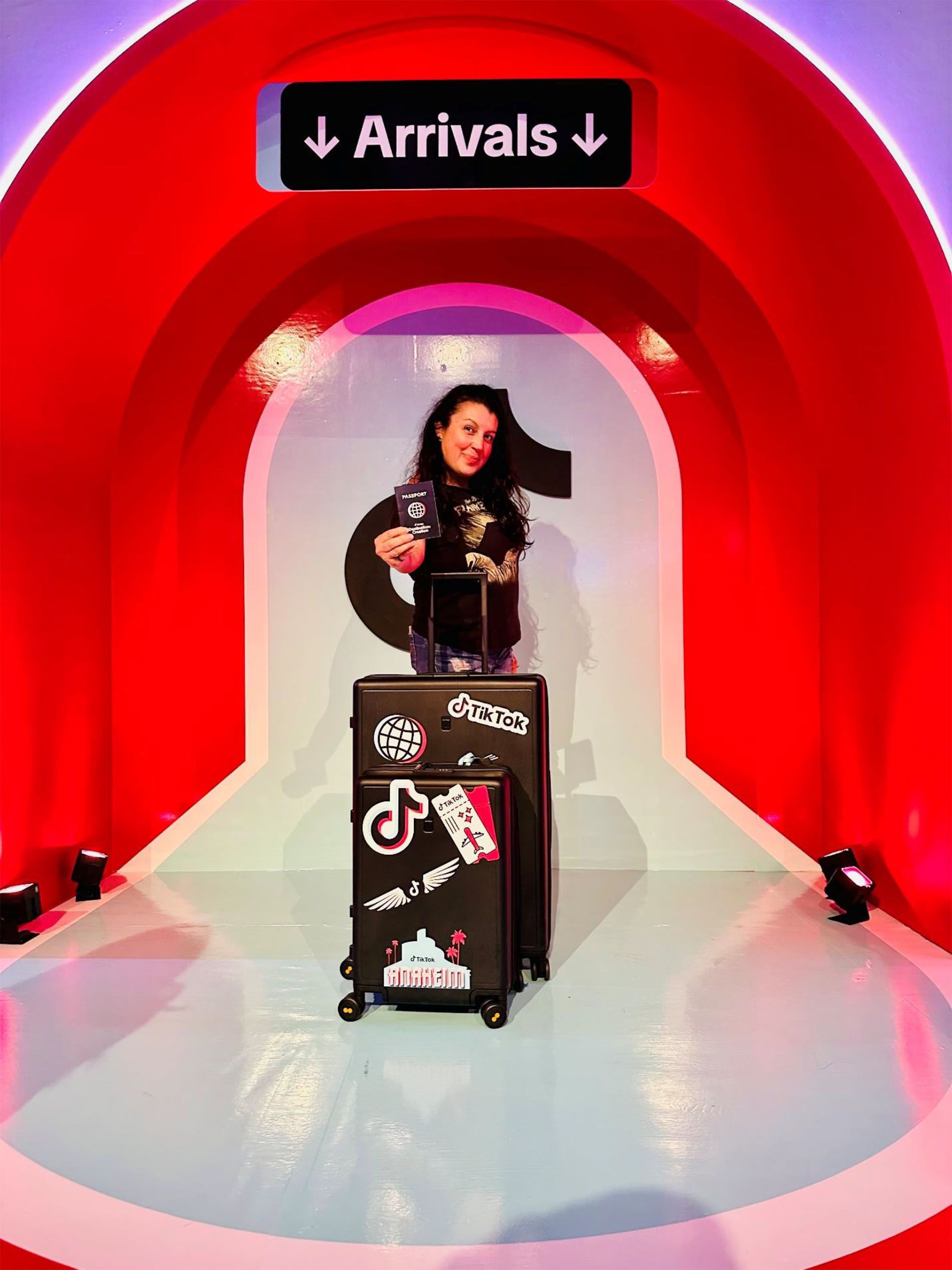 Woman in black outfit poses with suitcases