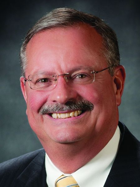 A man with glasses and a mustache is smiling for the camera.