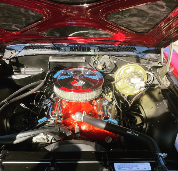 A close up of a car engine with the hood open