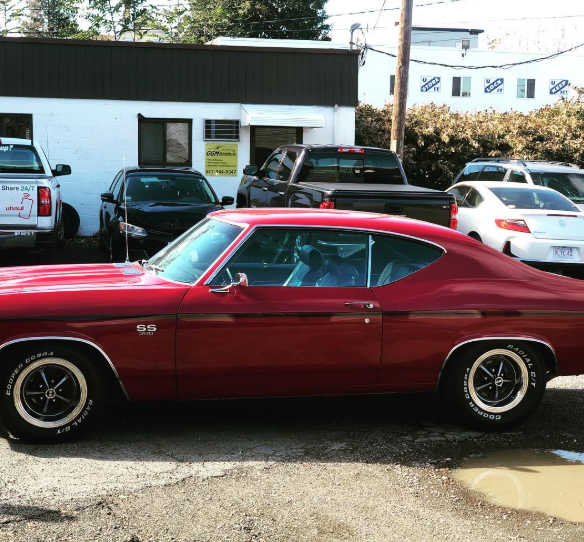 A red car is parked in front of a building