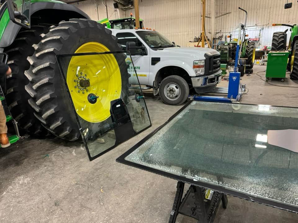 A john deere tractor is being repaired in a garage.