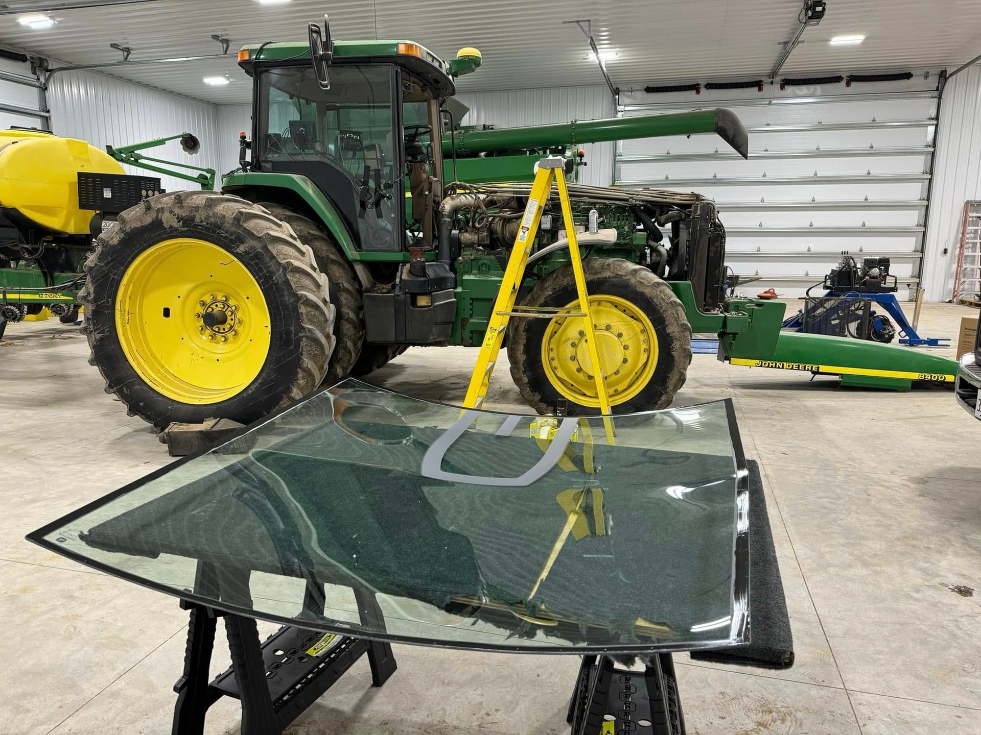 A john deere tractor is being repaired in a garage