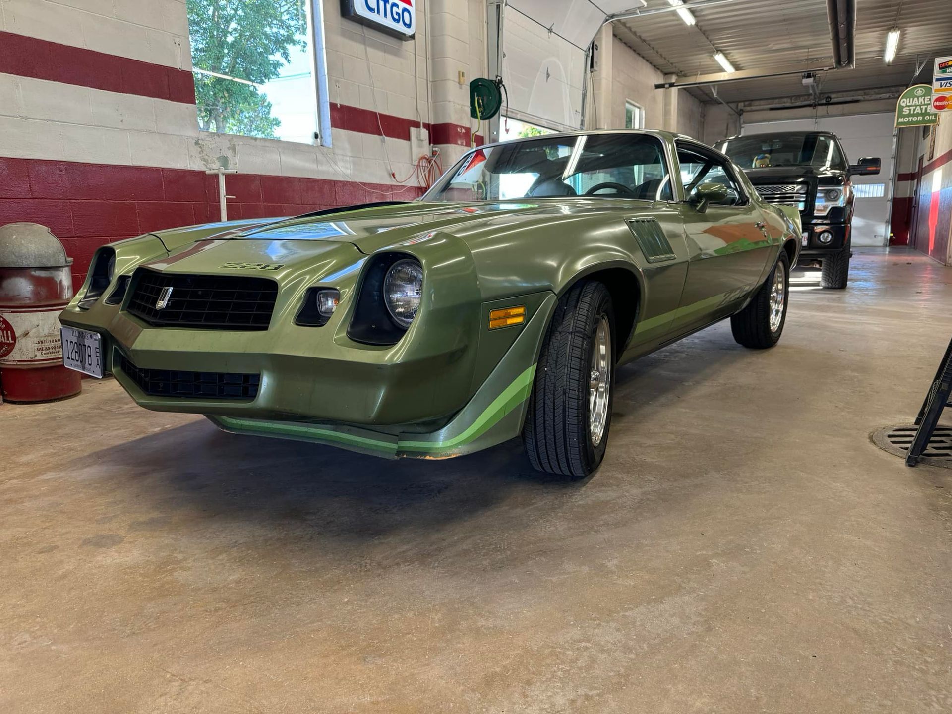 A green car is parked in a garage.