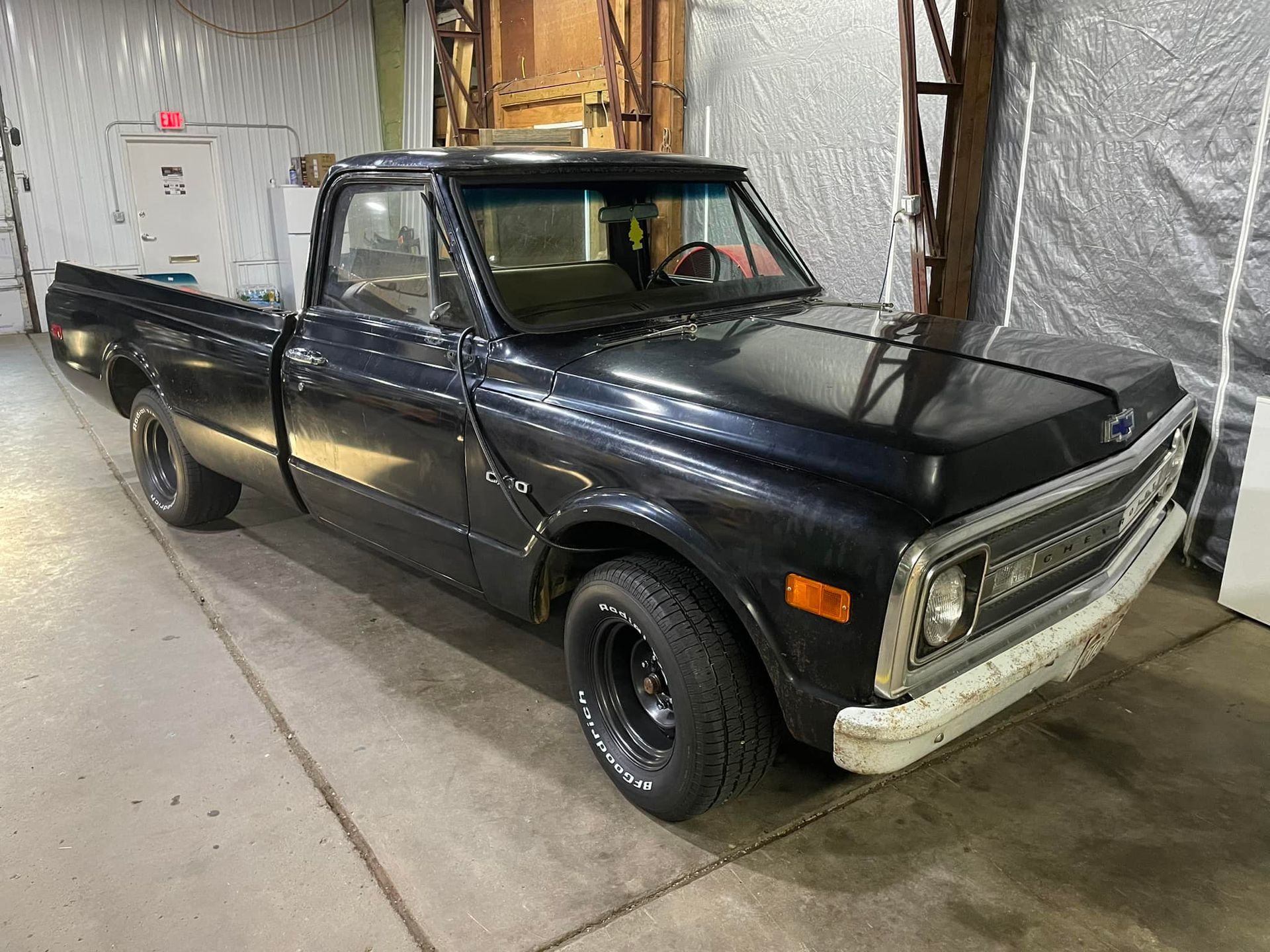 A black pickup truck is parked in a garage.