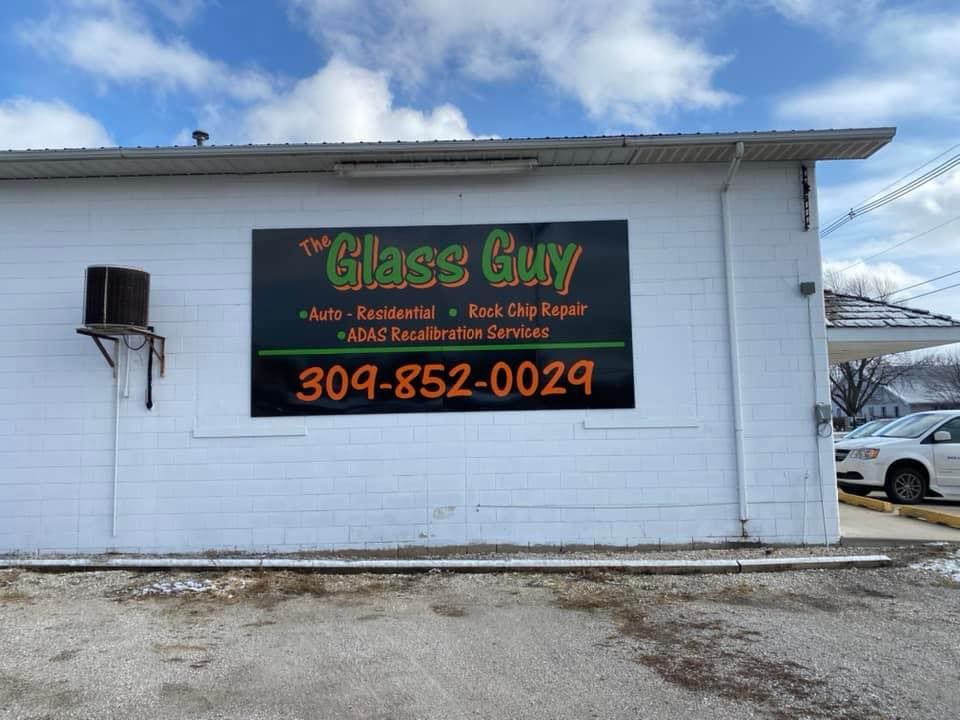 A sign on the side of a building that says glass guy