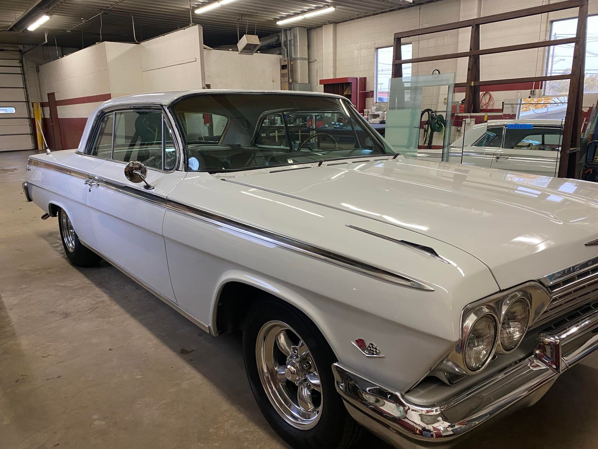 A white car is parked in a garage.