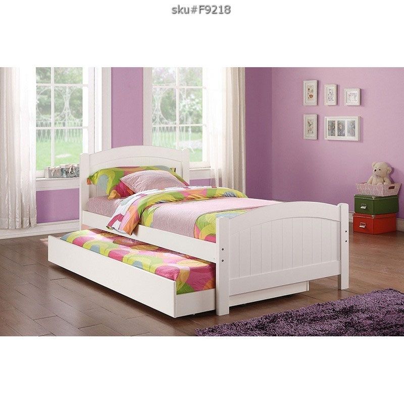 white trundle bed with colorful bedsheets
