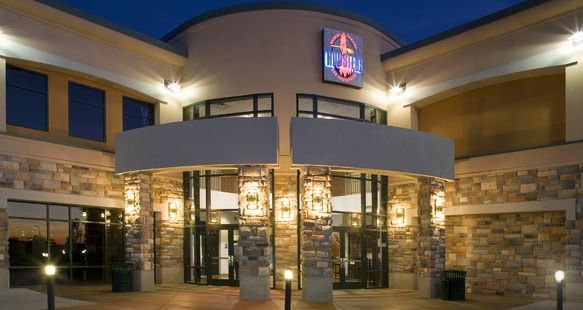 The exterior of the U-Star building at twilight, featuring stone-accented walls, glass doors, and illuminated signage.