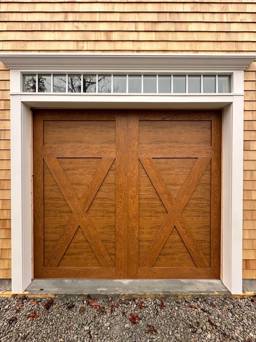 The garage door is made of wood and has a cross