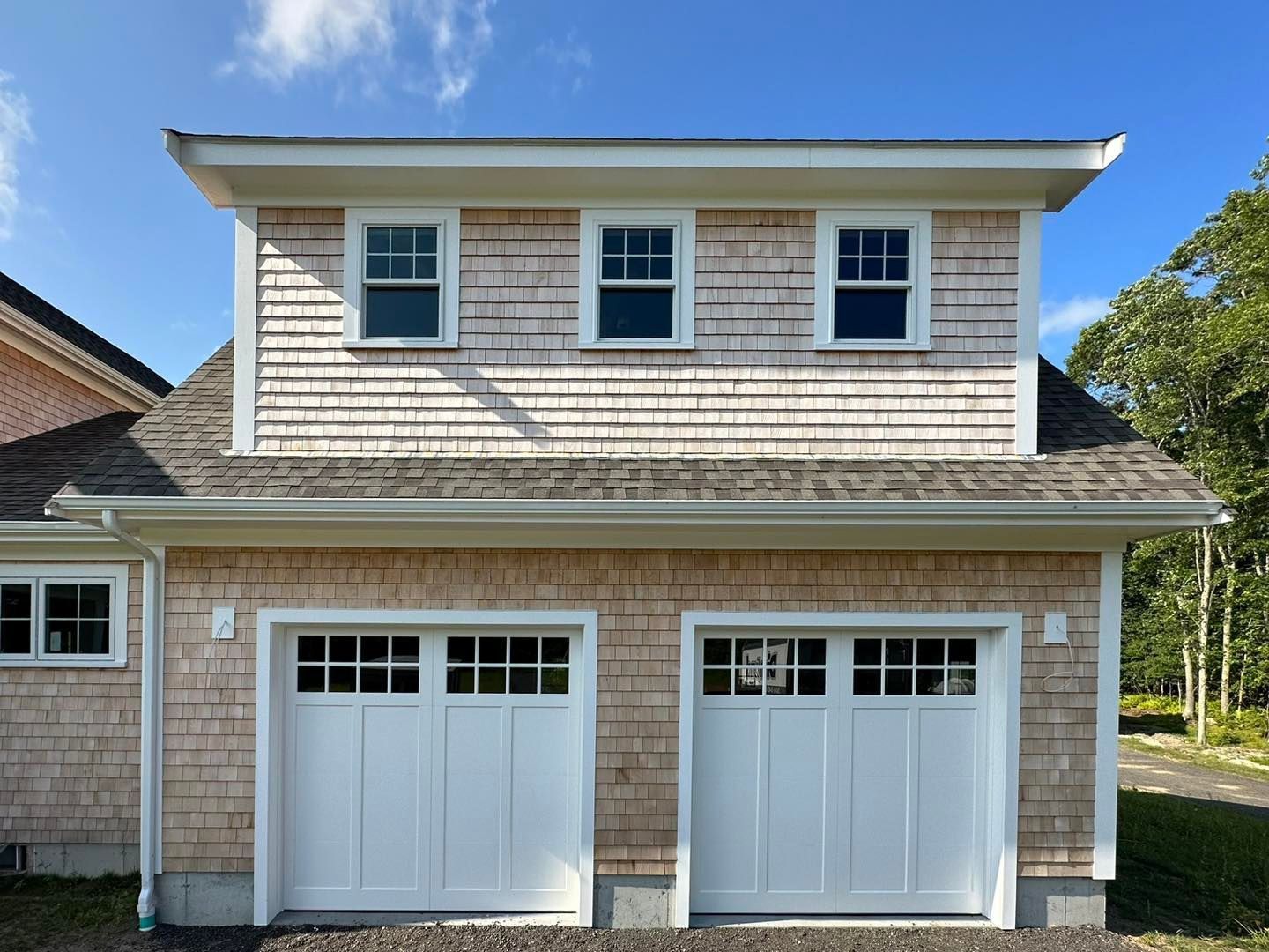 A house with two white garage doors and a roof