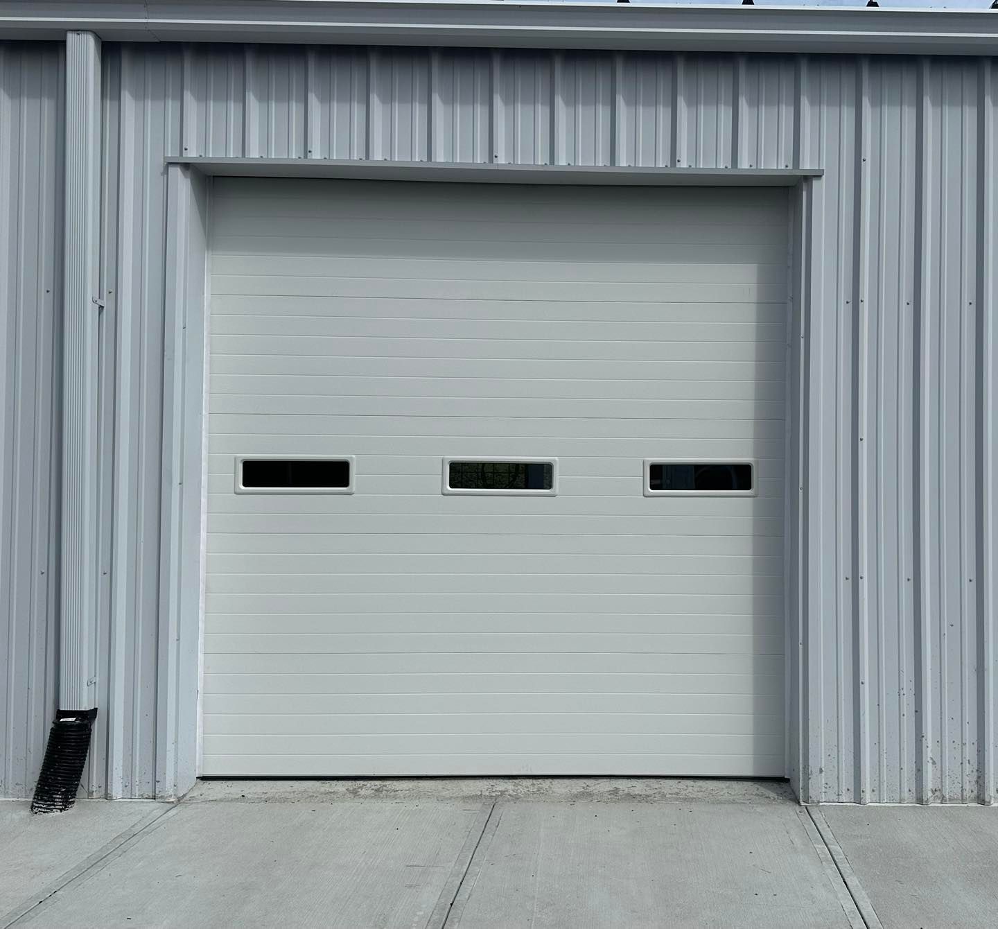 A white garage door is on the side of a building