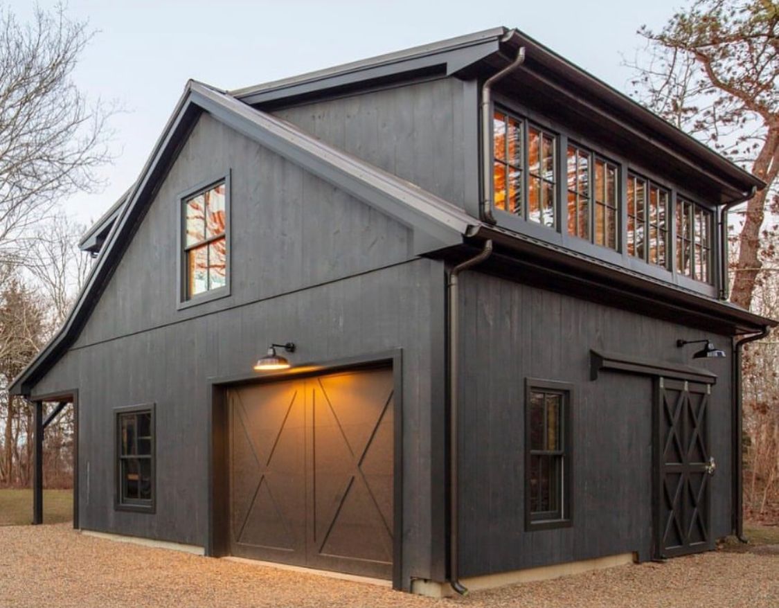 A black house with a garage and a second floor