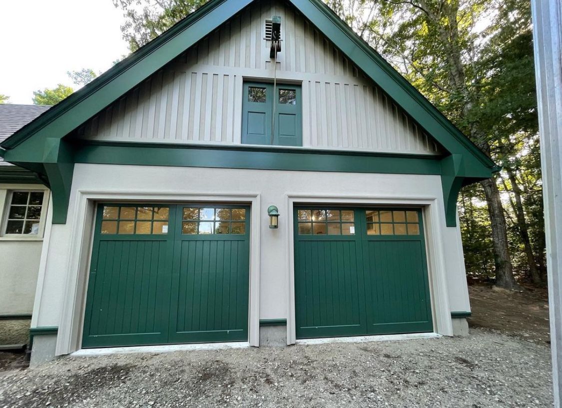 A white house with green garage doors