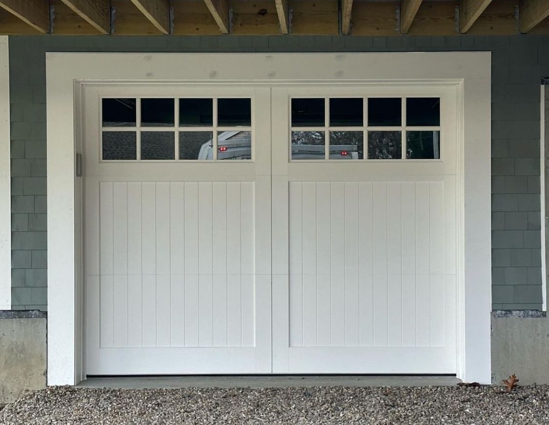 A white garage door with a reflection of a car in it