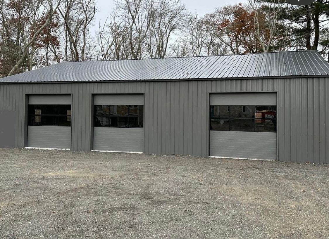 A gray garage and a black roof