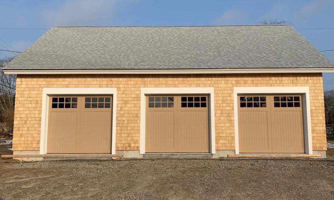 A garage with three brown garage doors