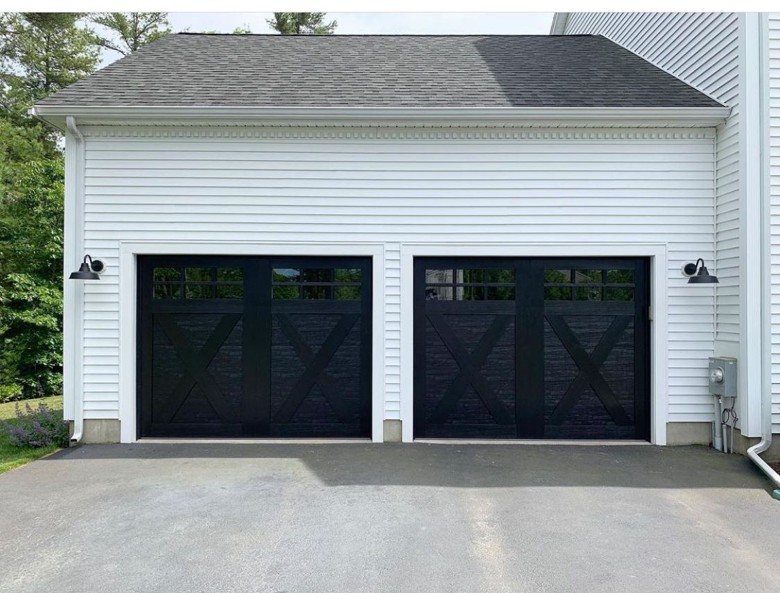 A white house with two black garage doors