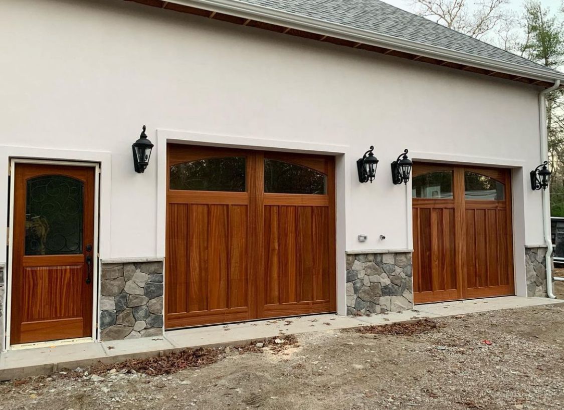 A white building with wooden garage doors 
