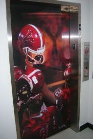 An elevator with a picture of a football player on the door.