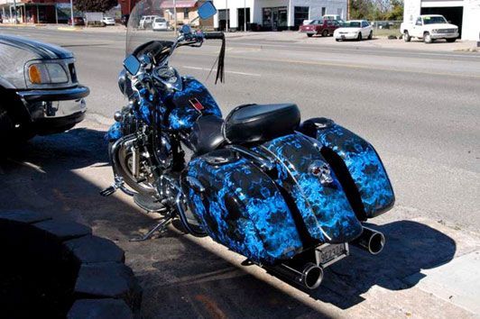 A blue and black motorcycle is parked on the side of the road