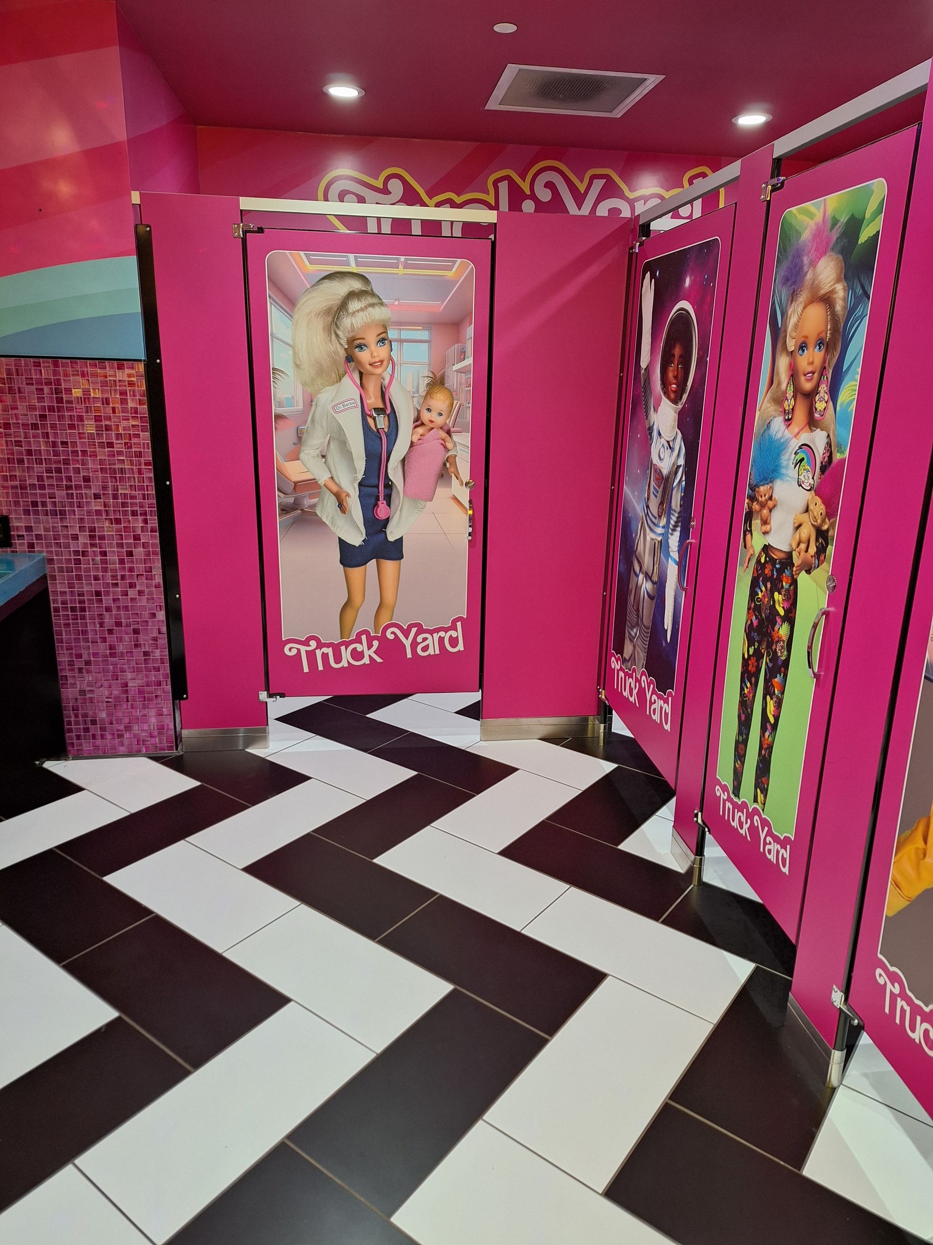 A barbie bathroom with a black and white tile floor