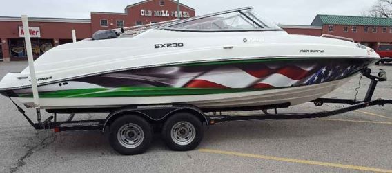 A boat is parked on a trailer in a parking lot.