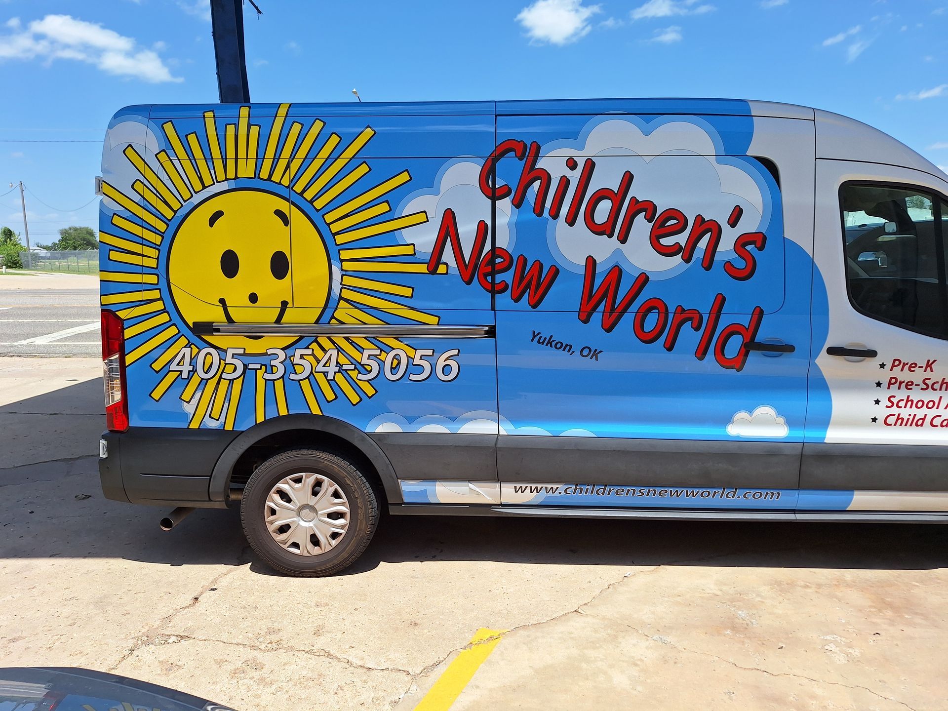 A children 's new world van is parked in a parking lot