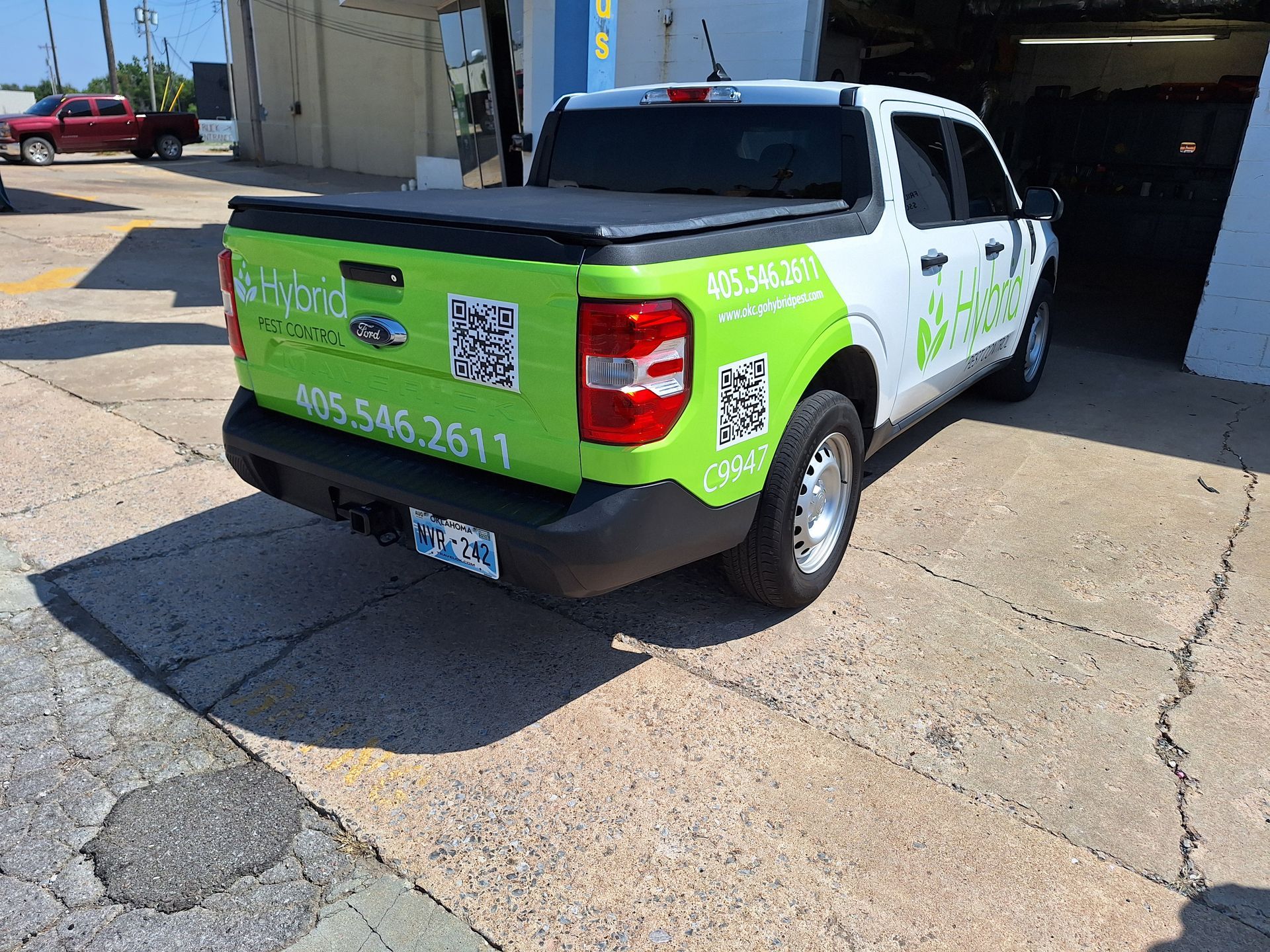 A green and white truck is parked on the side of the road.