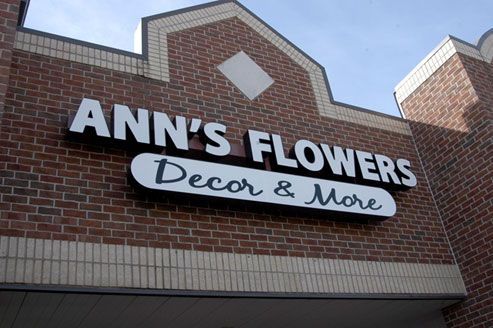 A brick building with a sign that says ann 's flowers decor & more