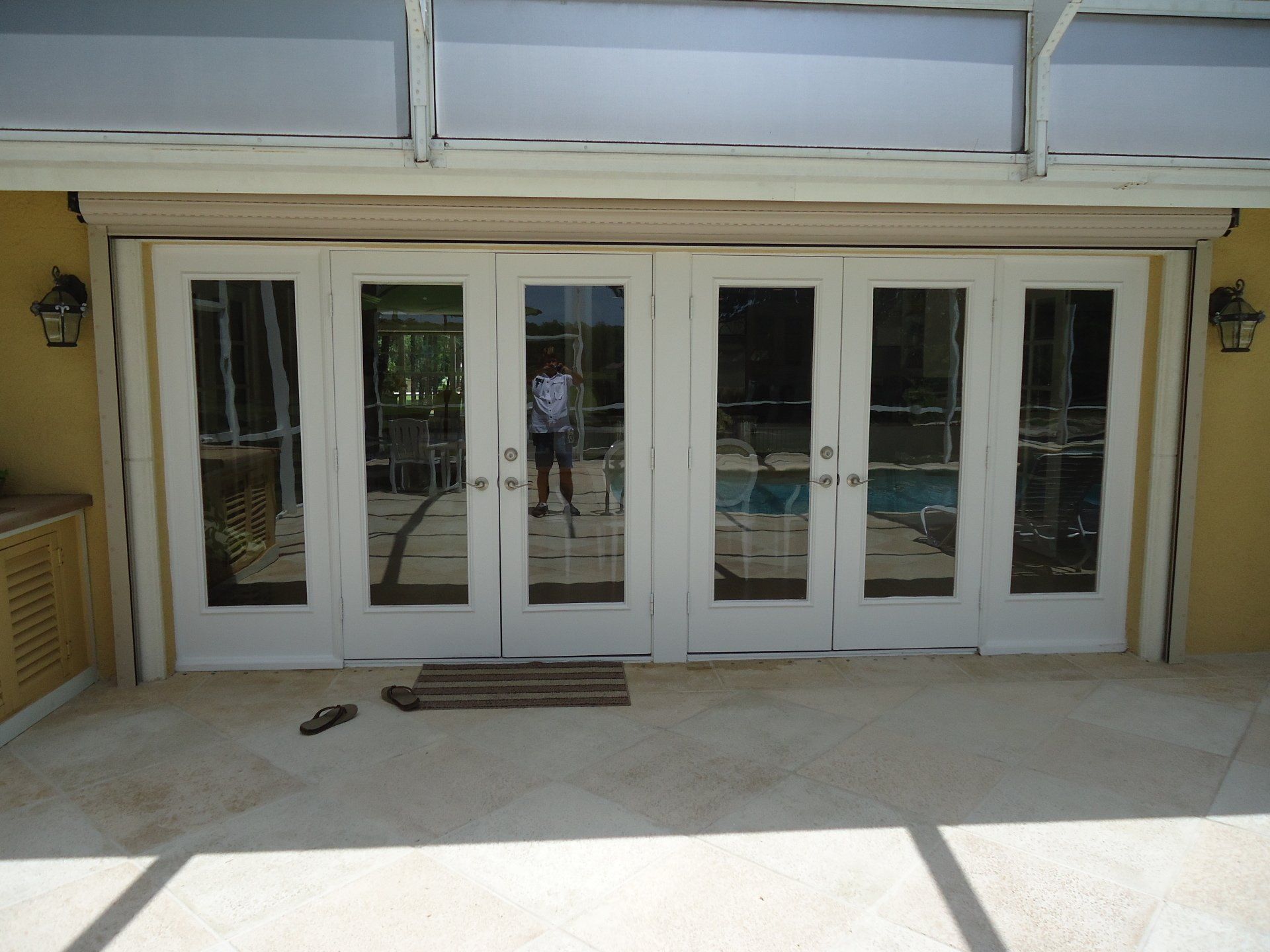 A man is standing in front of a patio with sliding glass doors