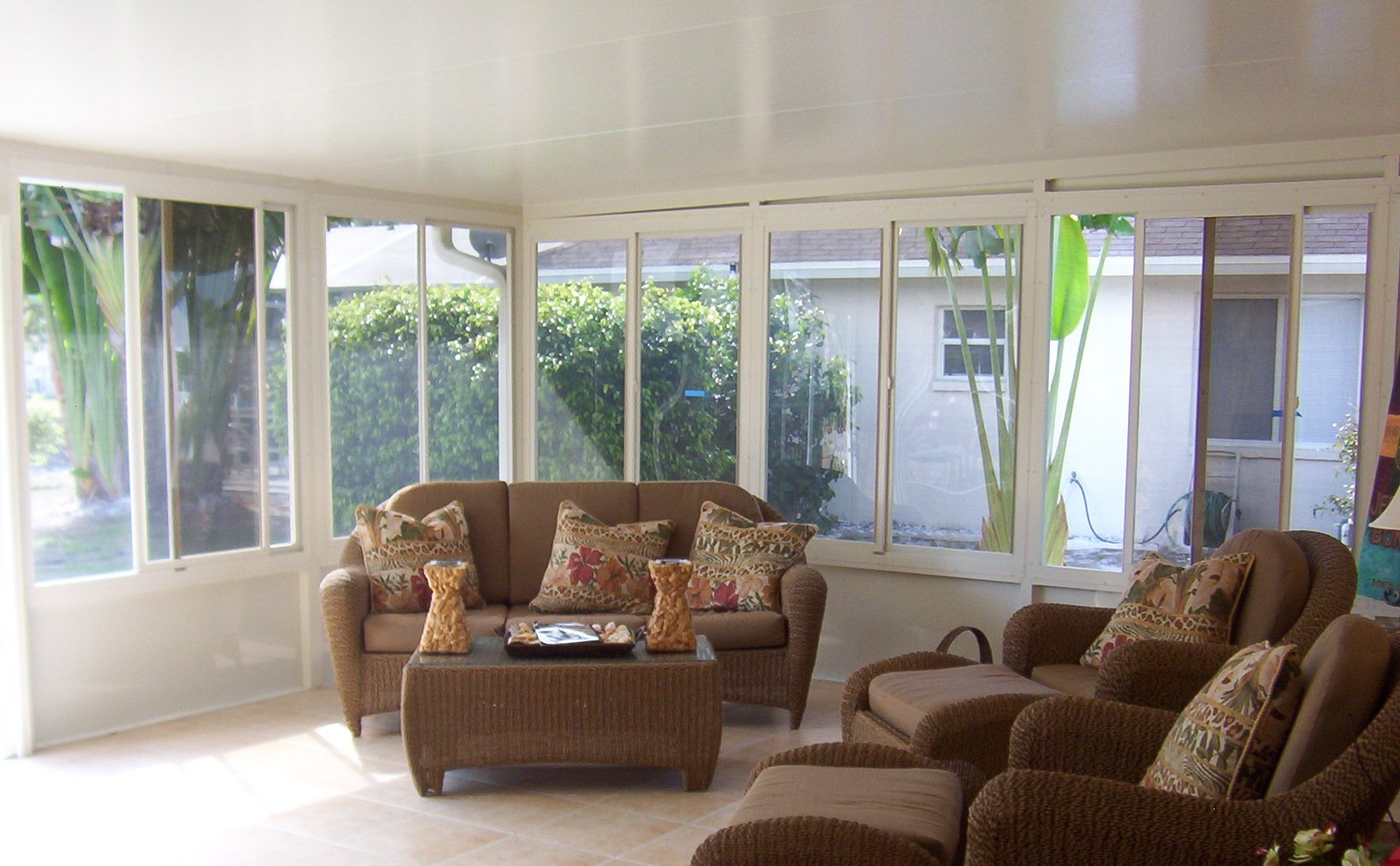 A living room with a couch and chairs and lots of windows