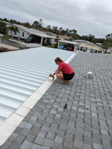 A woman is working on the roof of a house.